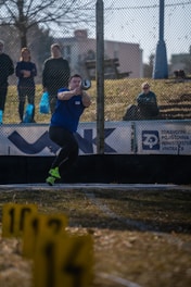 Athlete throws hammer in track and field event.