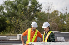 Construction workers are inspecting plans on the jobsite.