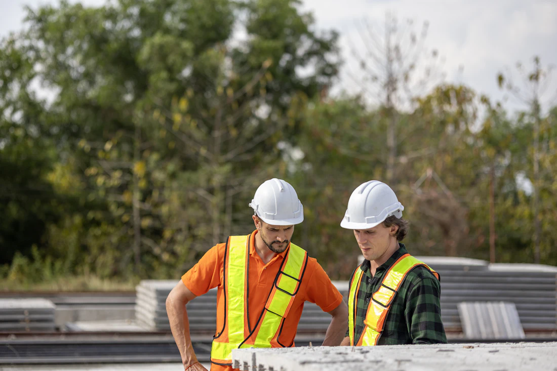 Técnicos de obra revisando planos en el exterior