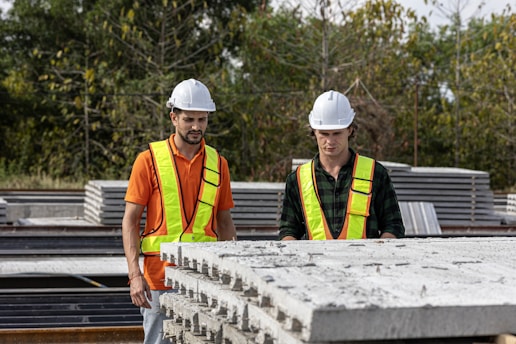 Construction workers inspect concrete slabs.
