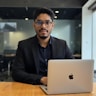 A man works on a laptop in an office.