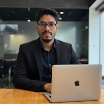A man works on a laptop in an office.