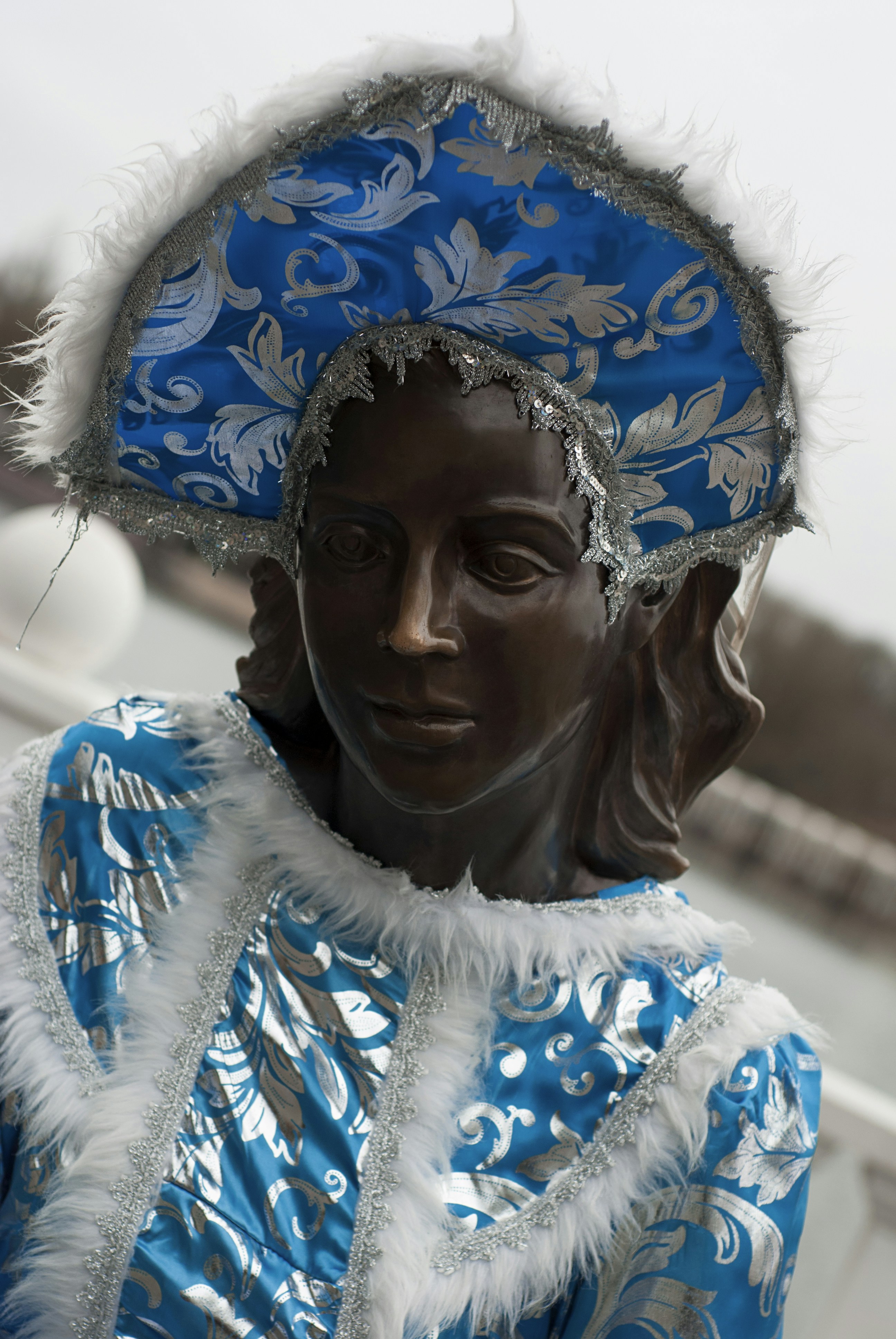 Une statue en bronze d’une femme en tenue bleue.