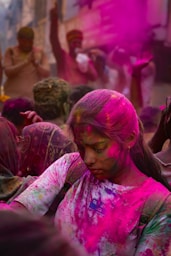 People covered in colorful powder celebrate holi.