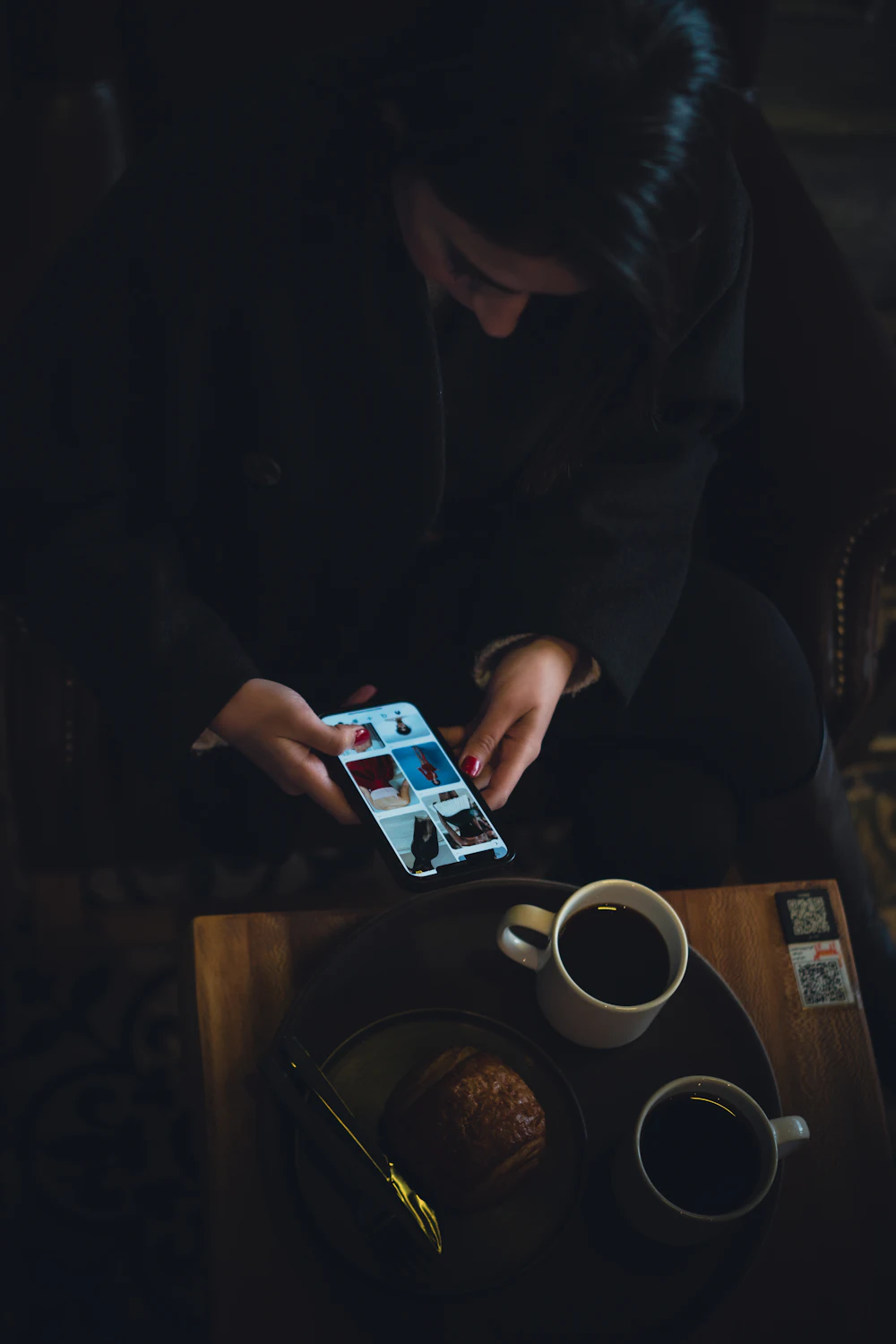 A person reading reviews on a phone over coffee.