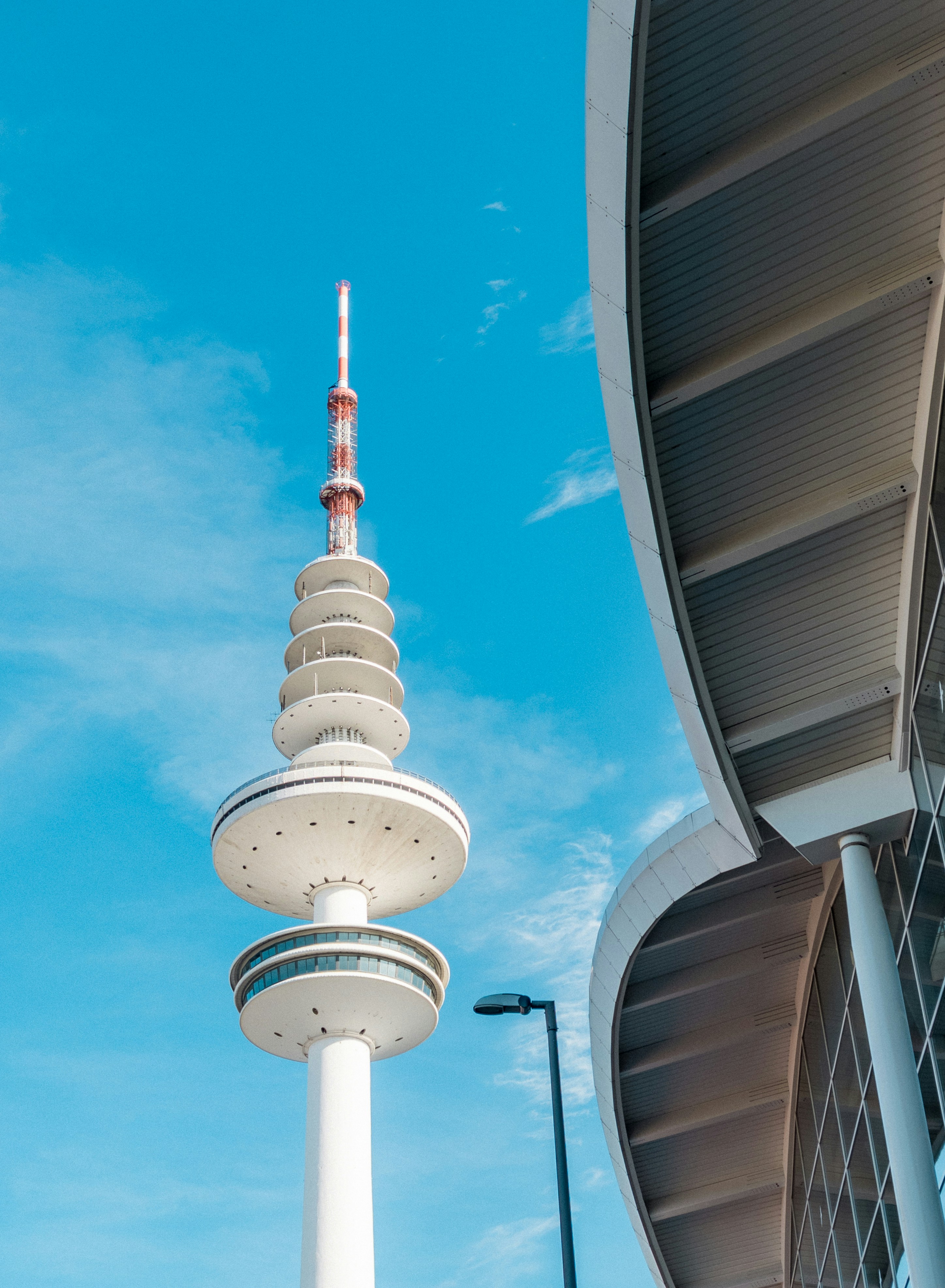 A tall tower stands next to a modern building.