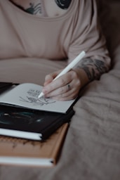 A person sketches in a notebook.