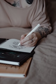 A person sketches in a notebook.