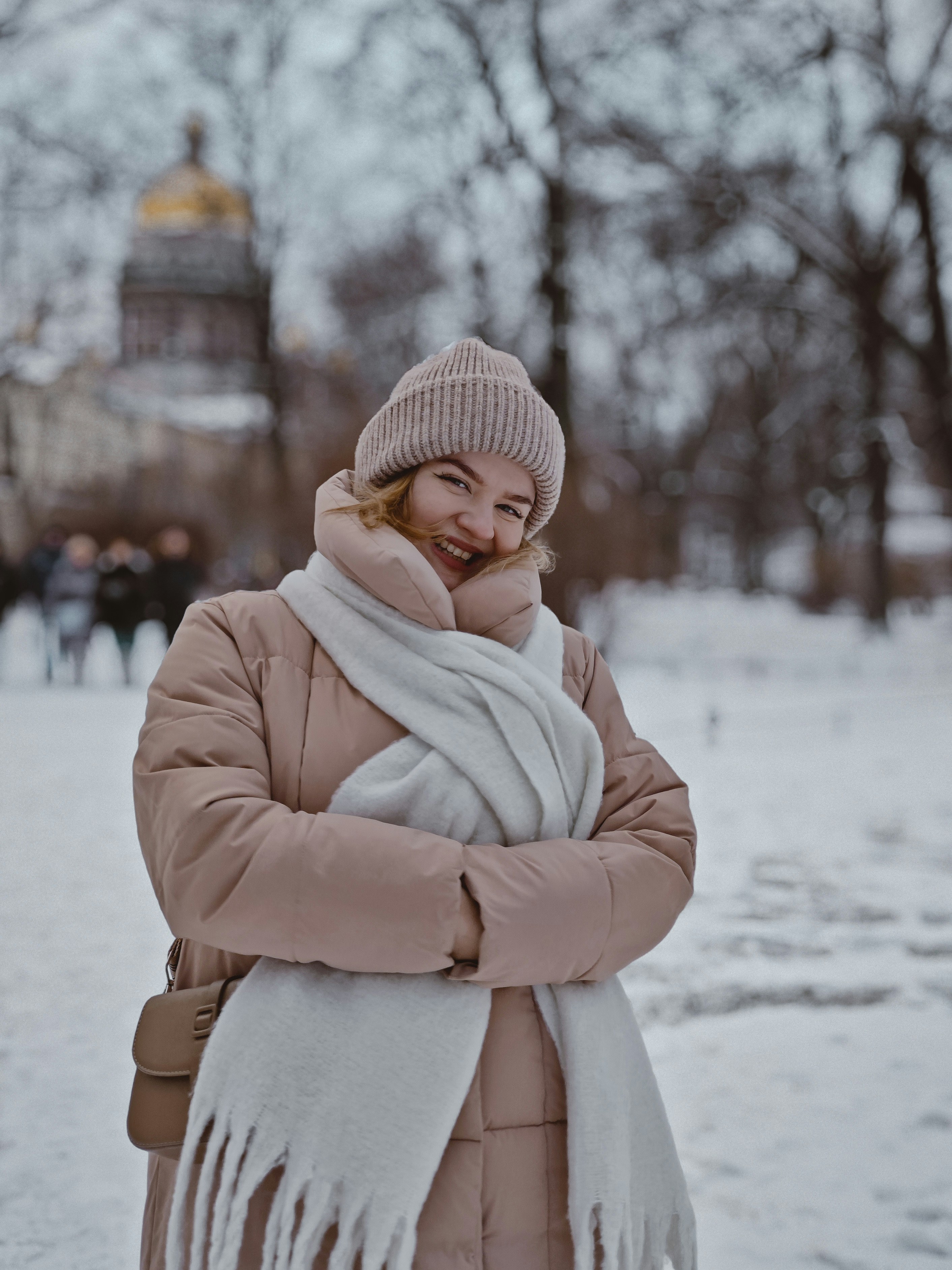 Smiling woman bundled up in the snow.