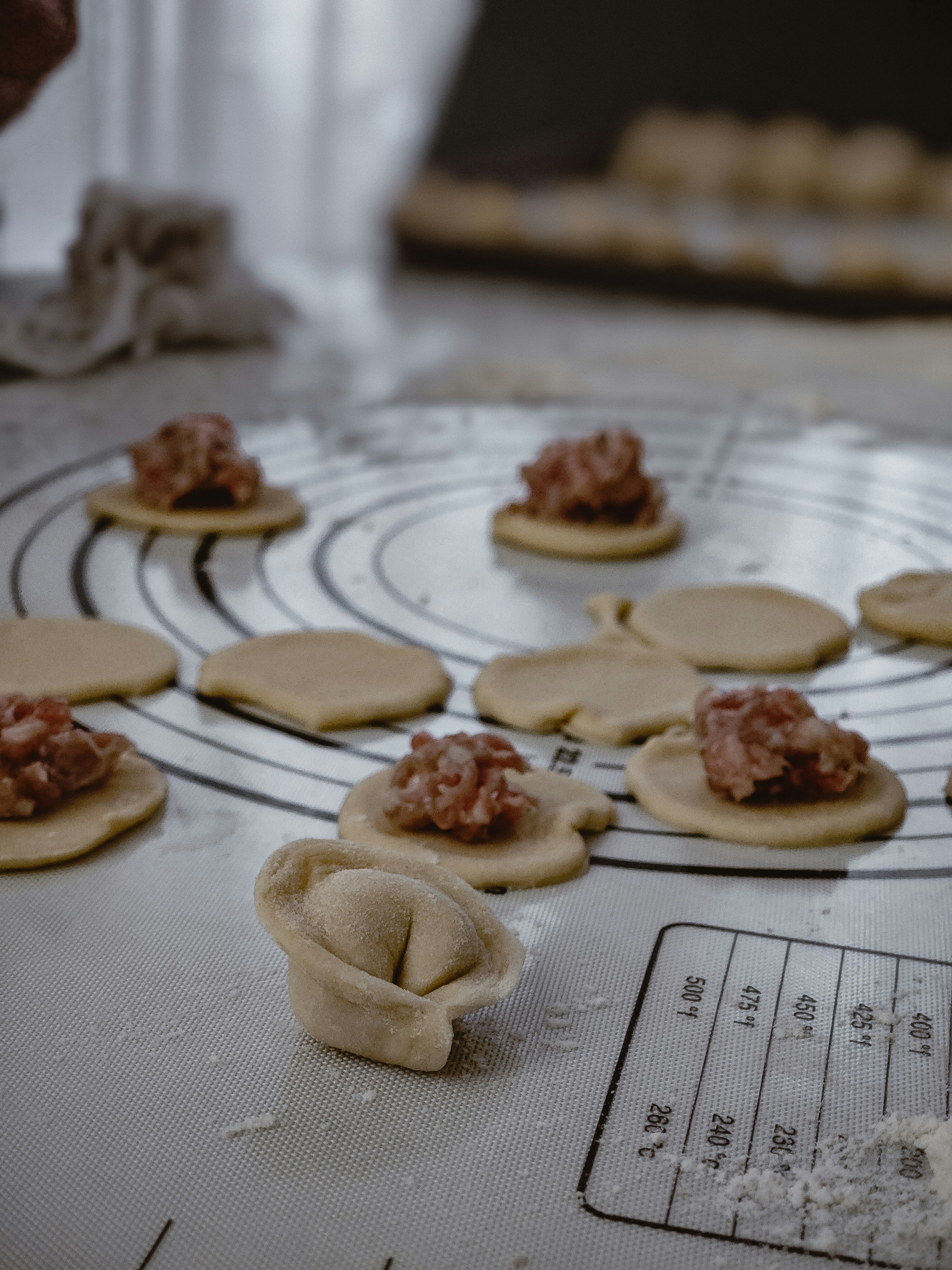 Making dumplings from scratch with raw meat.