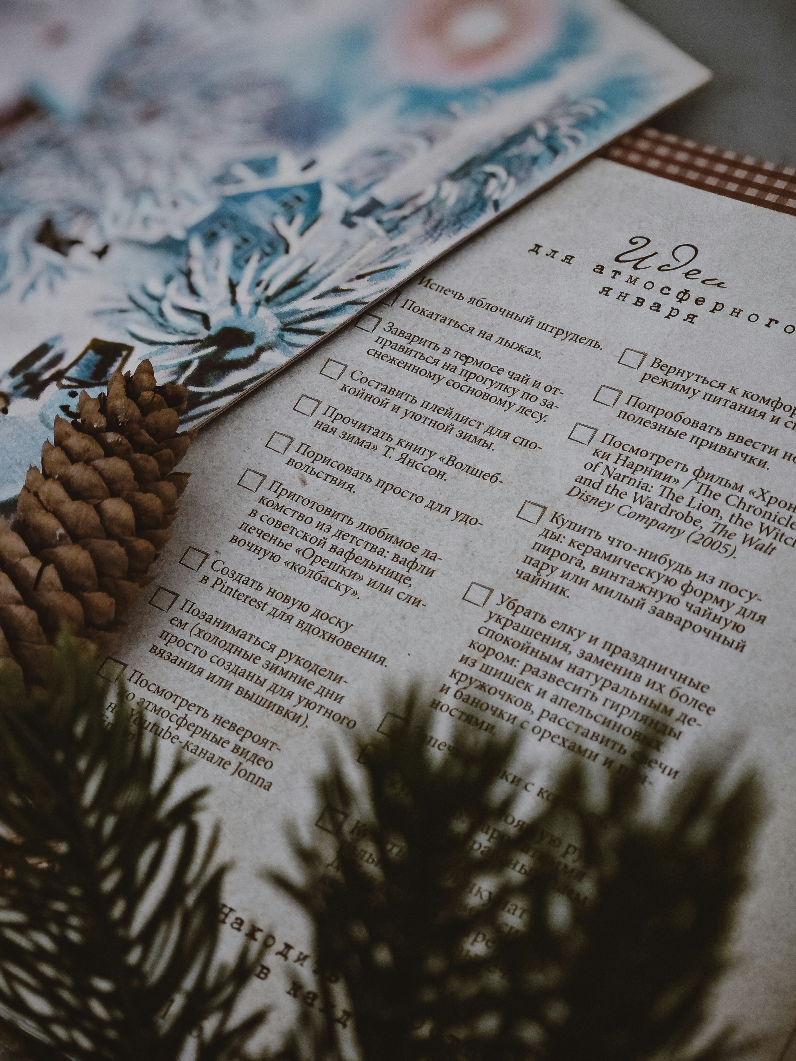 Winter-themed checklist and decorated paper with pine cone.