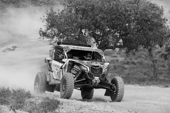 An off-road vehicle speeds through a dusty trail.