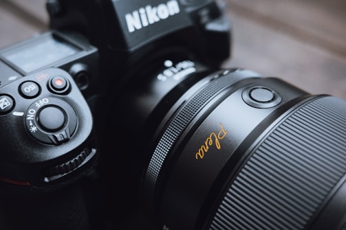 A nikon camera with a lens is visible.