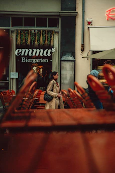 Woman walks past "emma's biergarten".