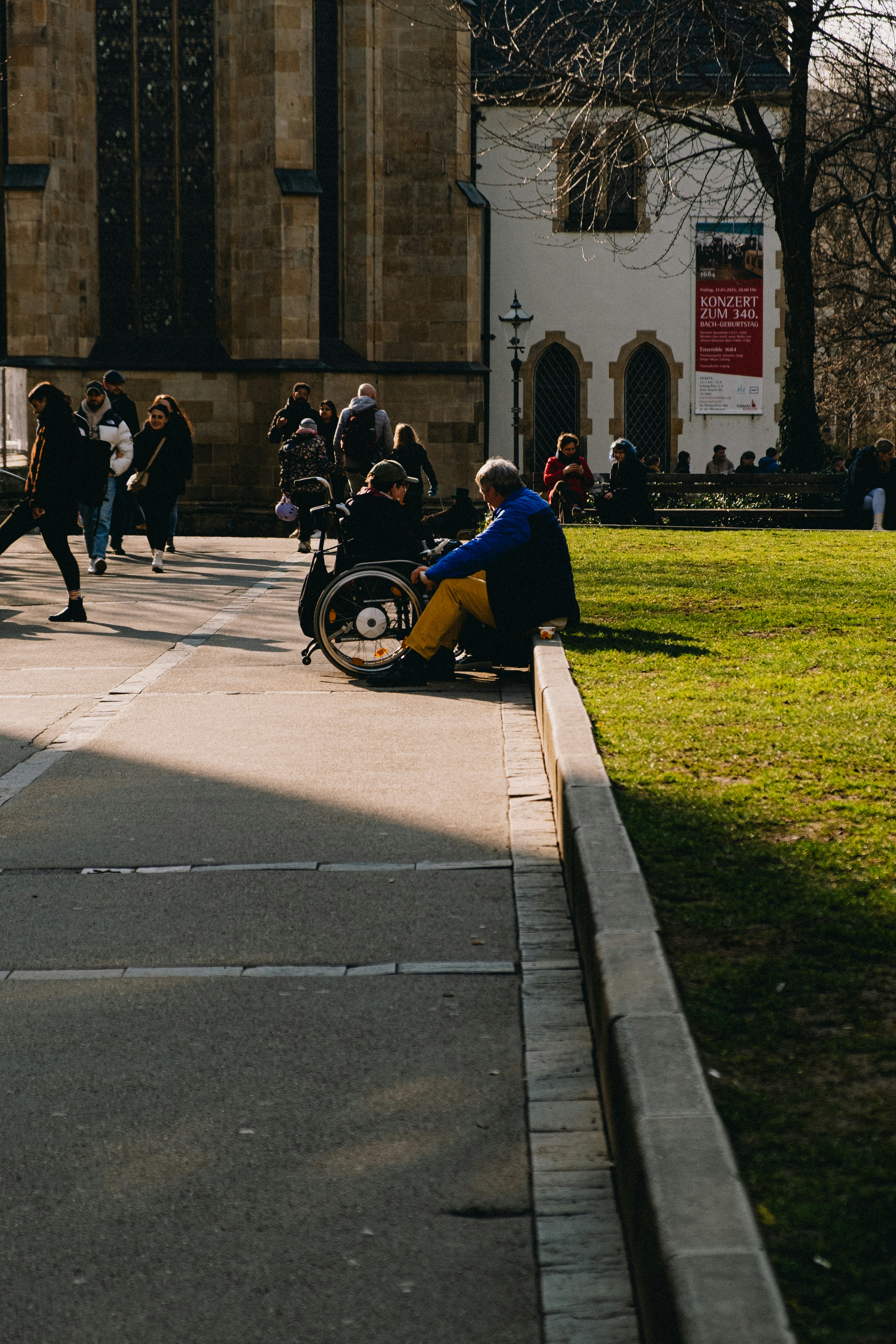 People relax by a park on a sunny day.