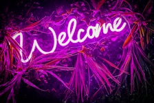 Neon welcome sign, bright and purple.