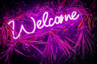 Neon welcome sign, bright and purple.