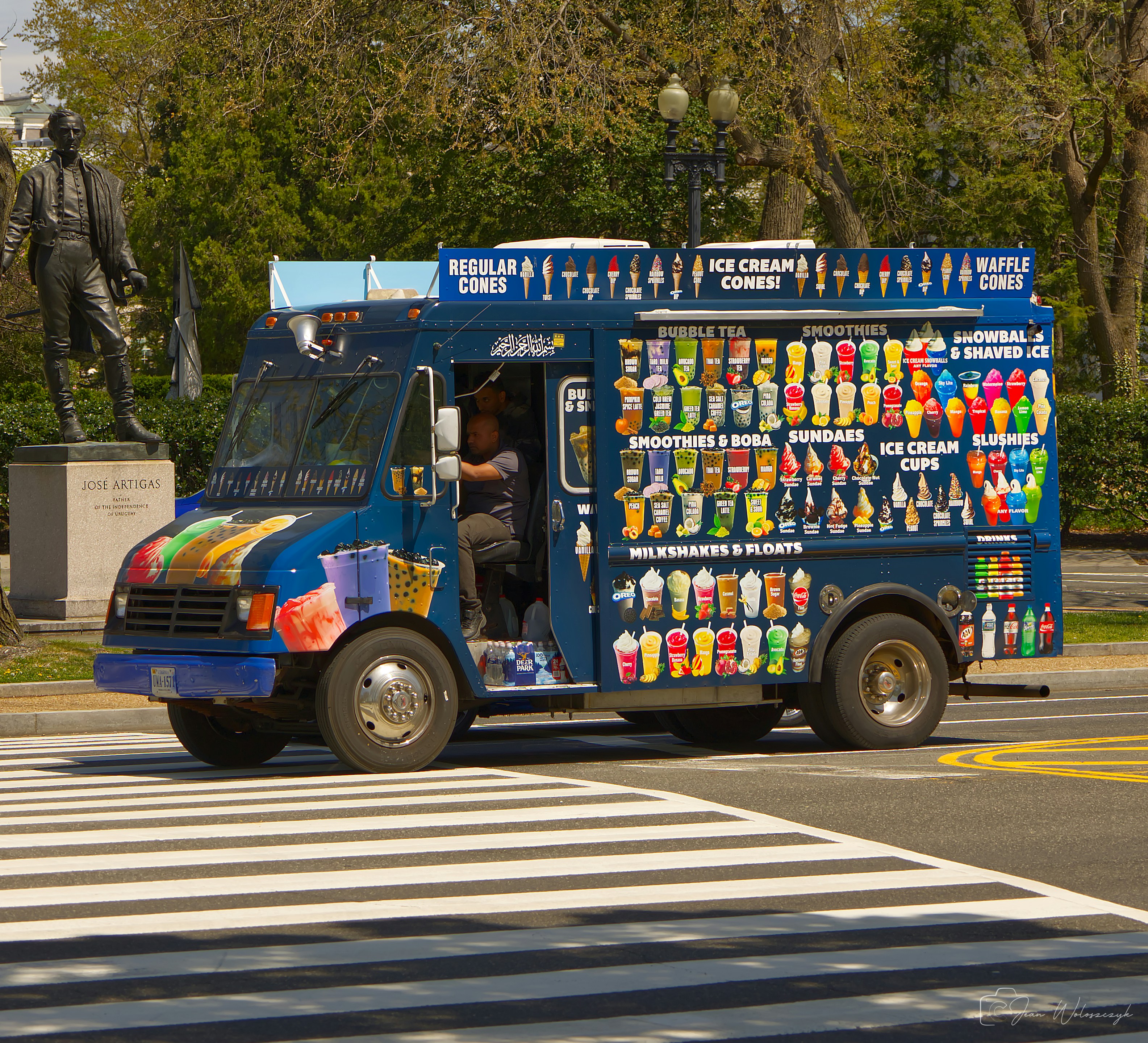 Ice cream truck driving across a crosswalk.