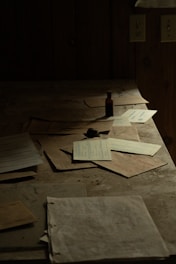 Papers and a small bottle rest on a dusty table.