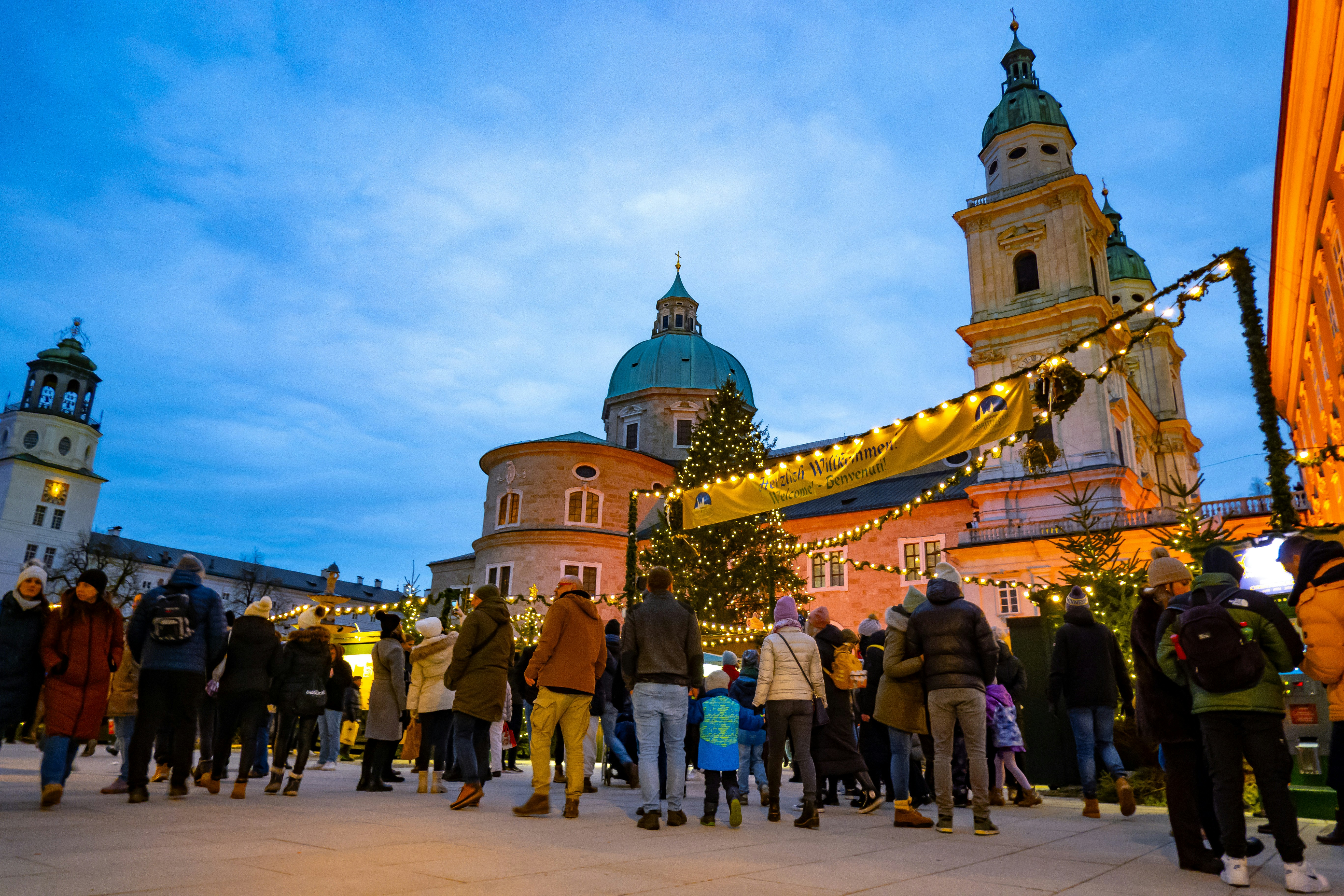 Christmas market with people and festive lights.