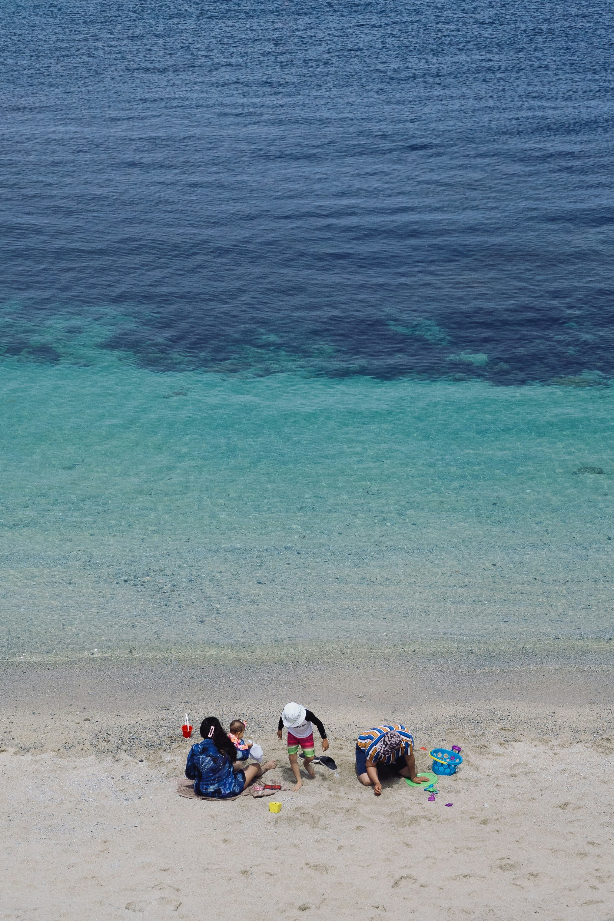 Family enjoys a day at the clear beach.