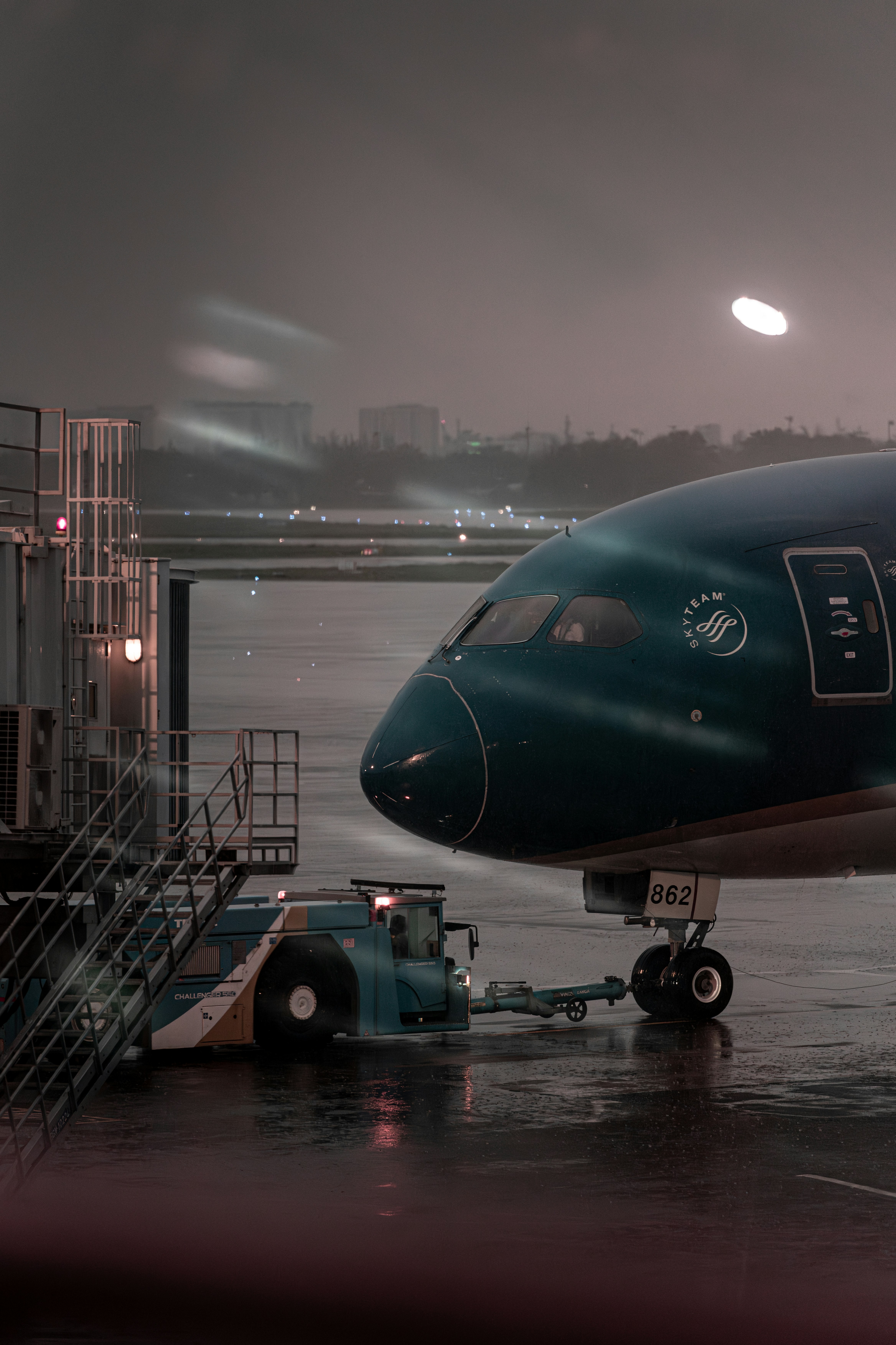 An airplane waits at the terminal during a storm.
