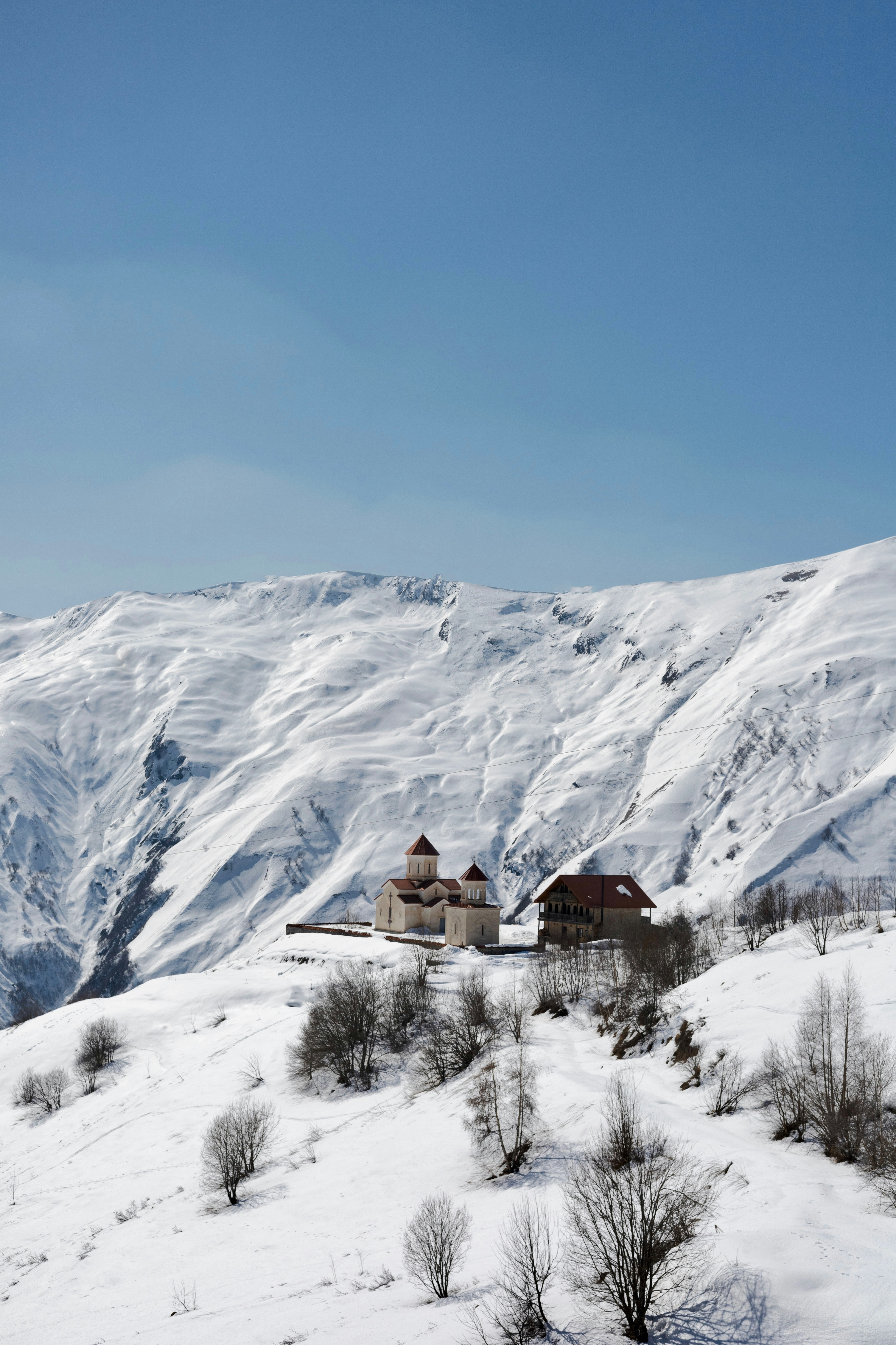 Church sits on snow-covered mountain.