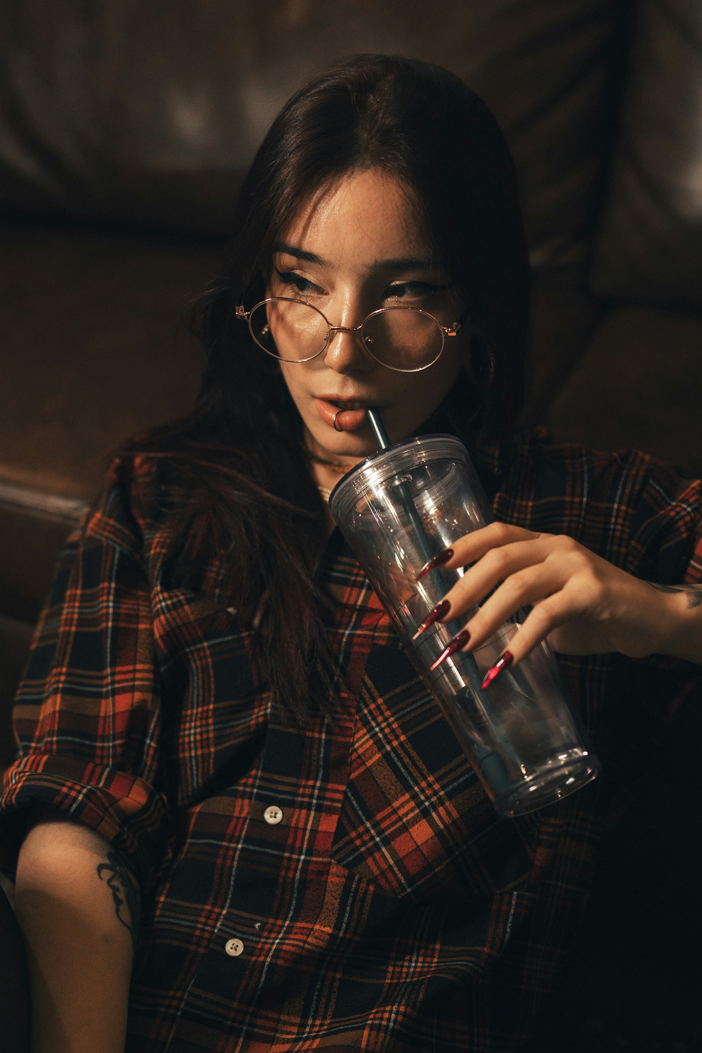 Young woman sips from a cup, relaxing.