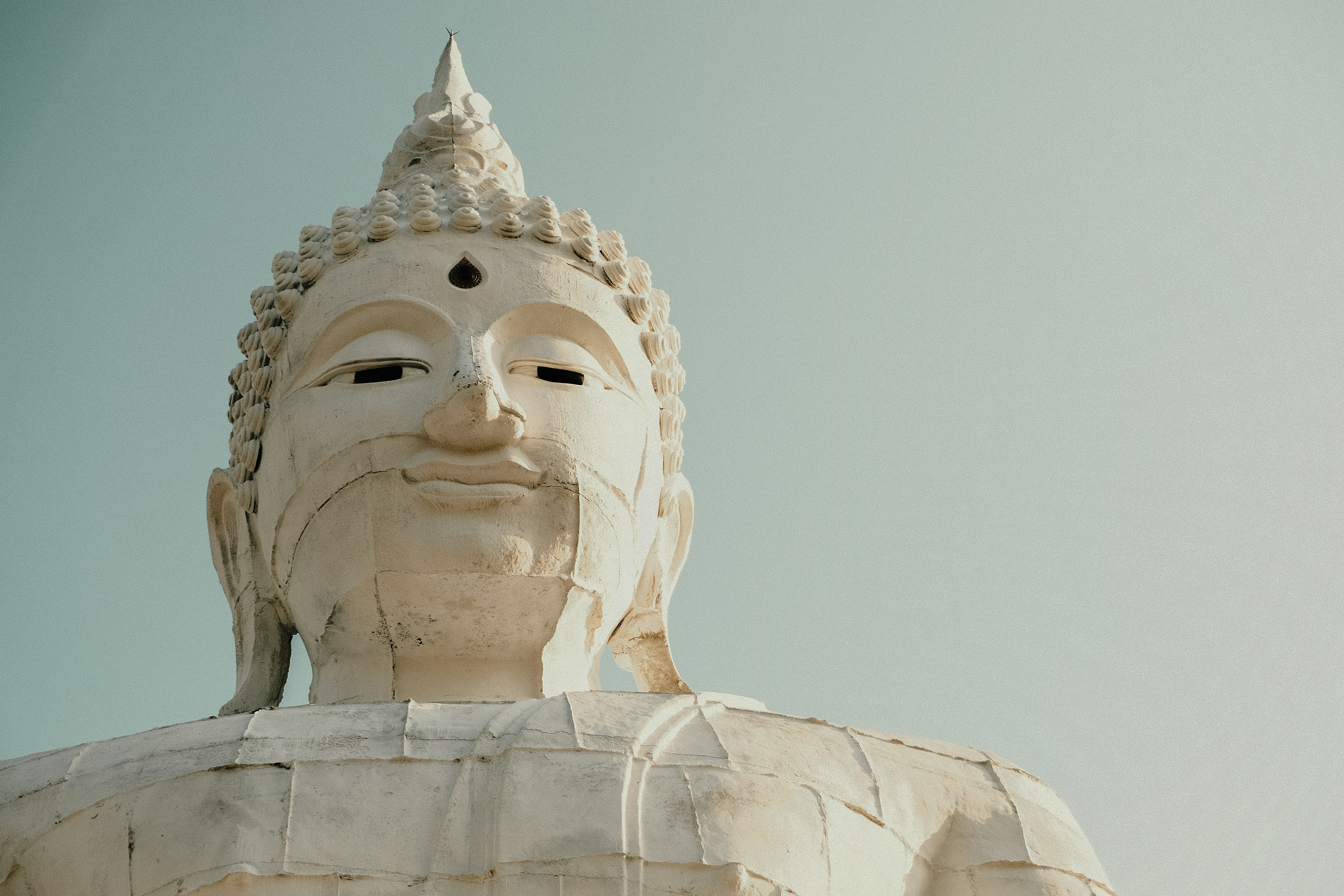 A peaceful buddha statue against the sky.