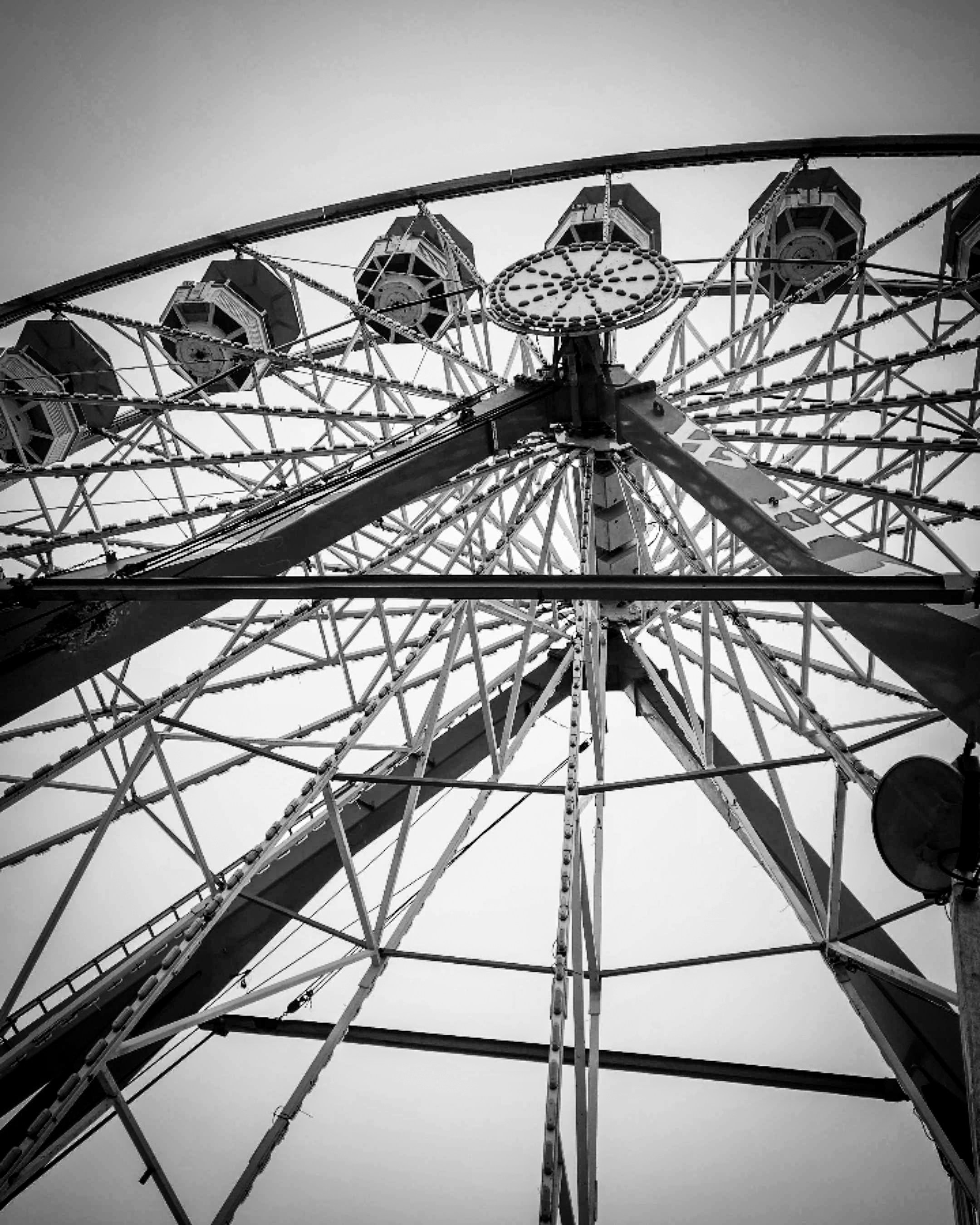 Ferris wheel viewed from below, in black and white.