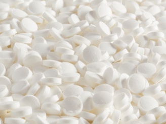 A pile of white tablets is shown.