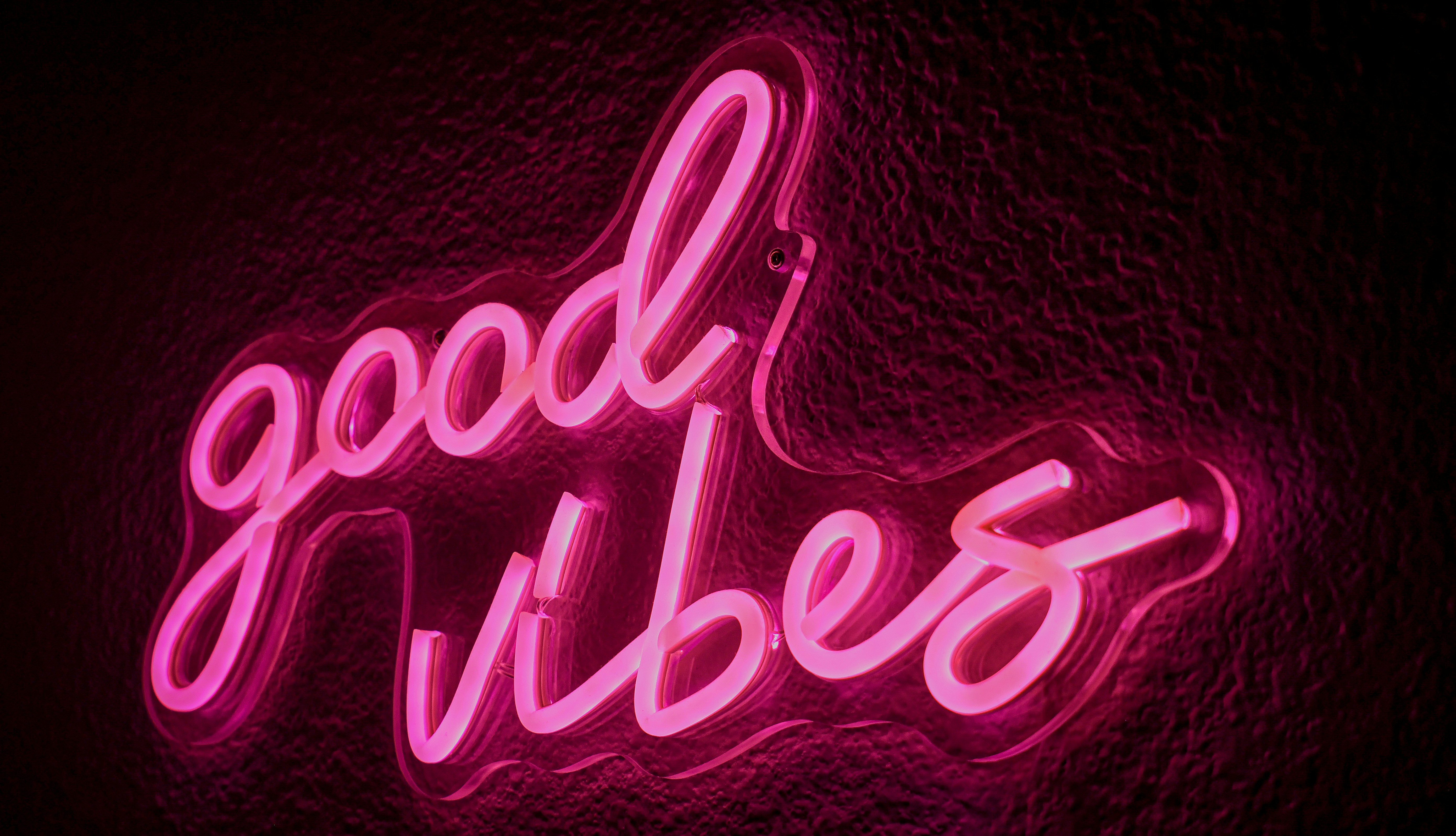 Neon sign reads "good vibes" in pink.