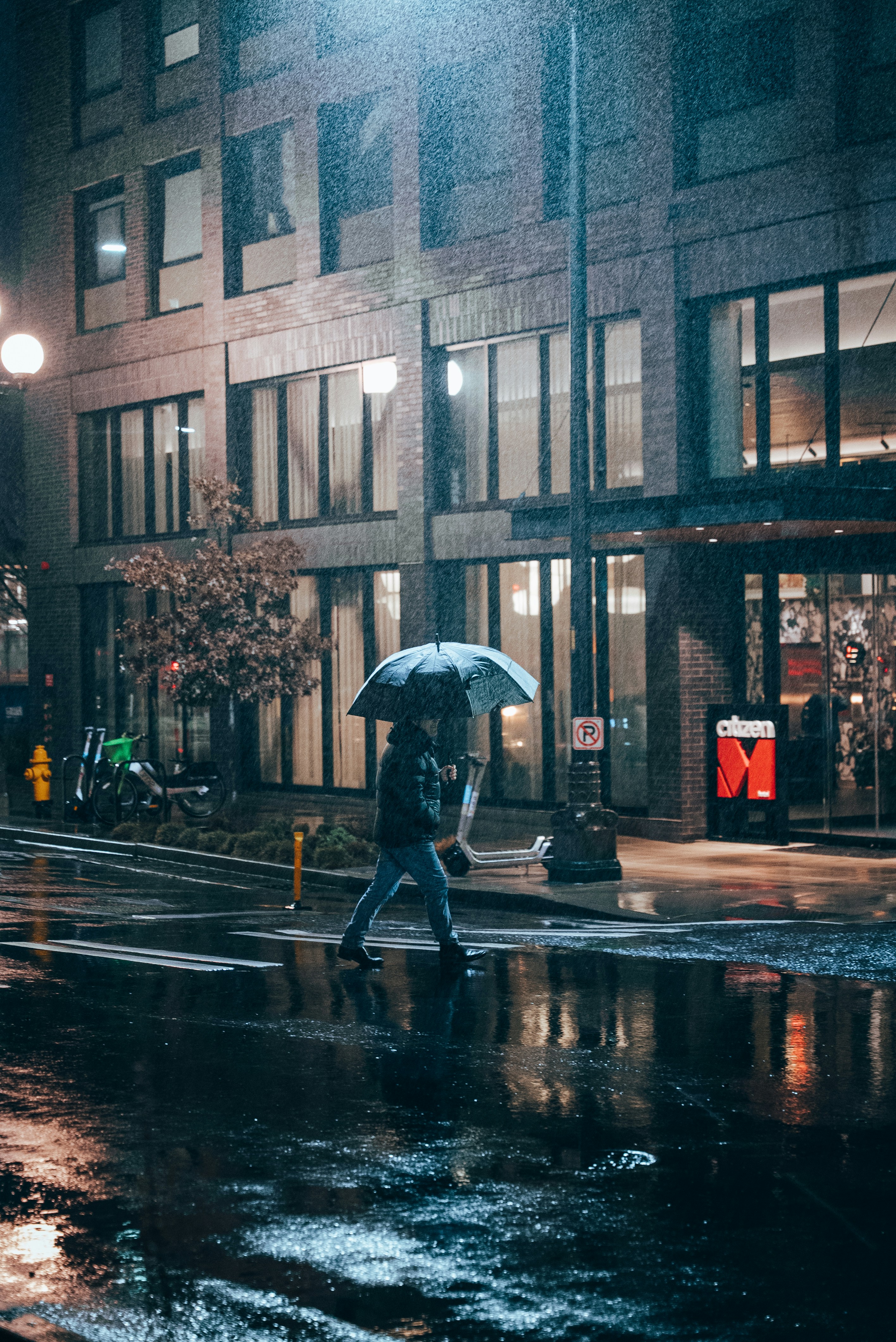 Person walking on crosswalk in the rain.