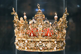 A royal golden crown displayed in a case