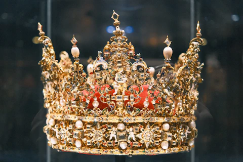 A royal golden crown displayed in a case