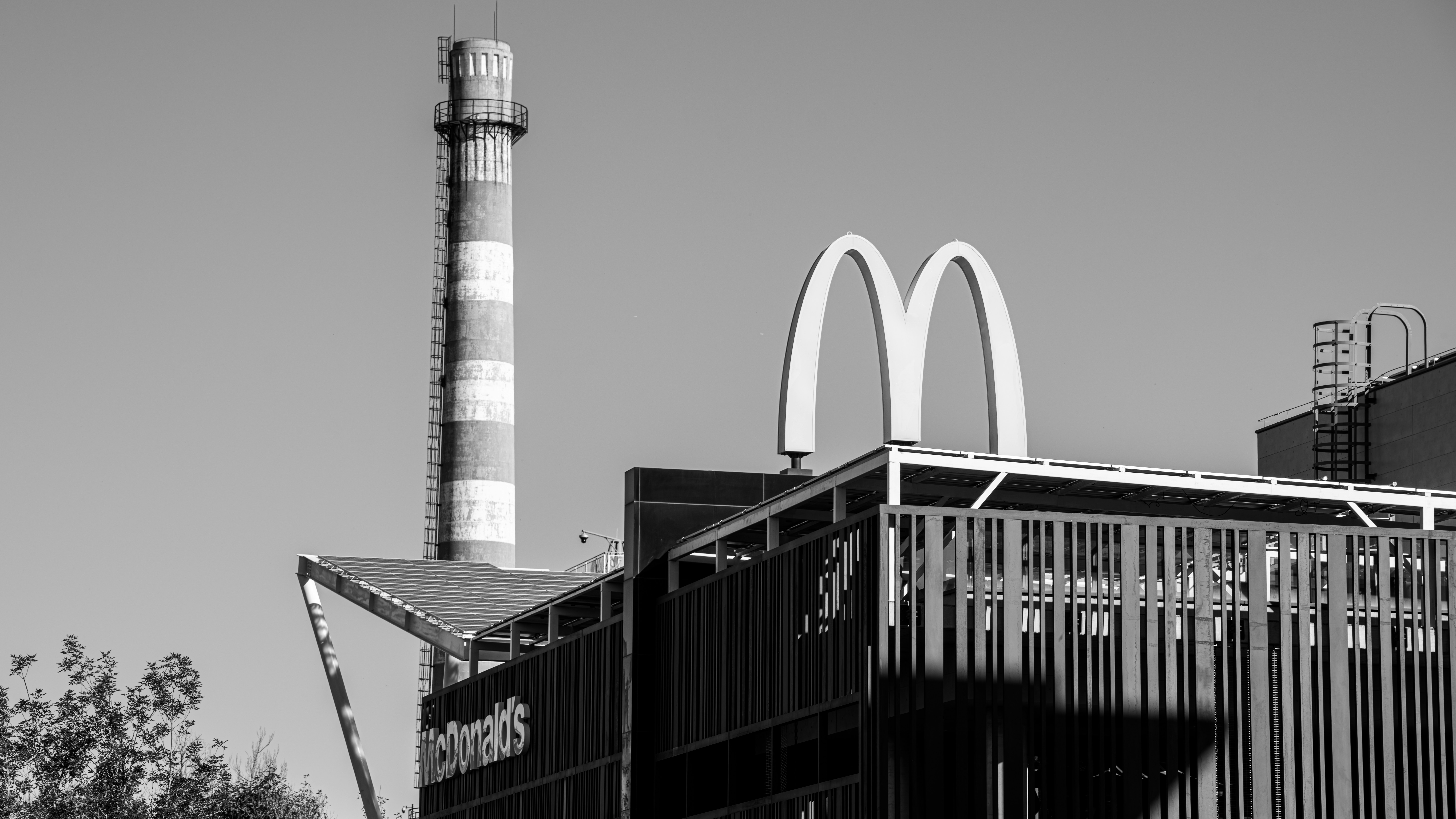 Mcdonald's arches stand tall near a chimney.