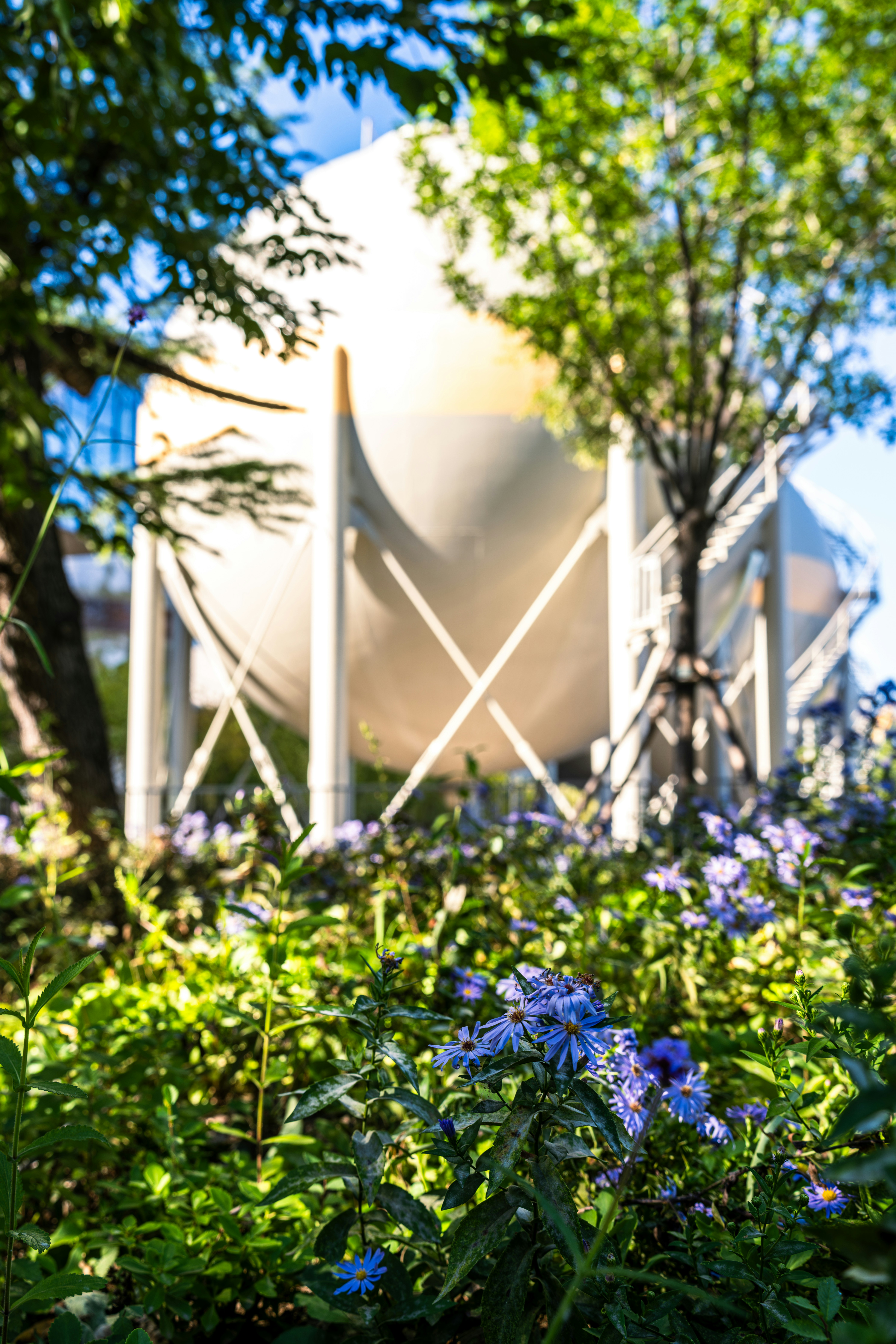 Flowers in front of a large, white tank.