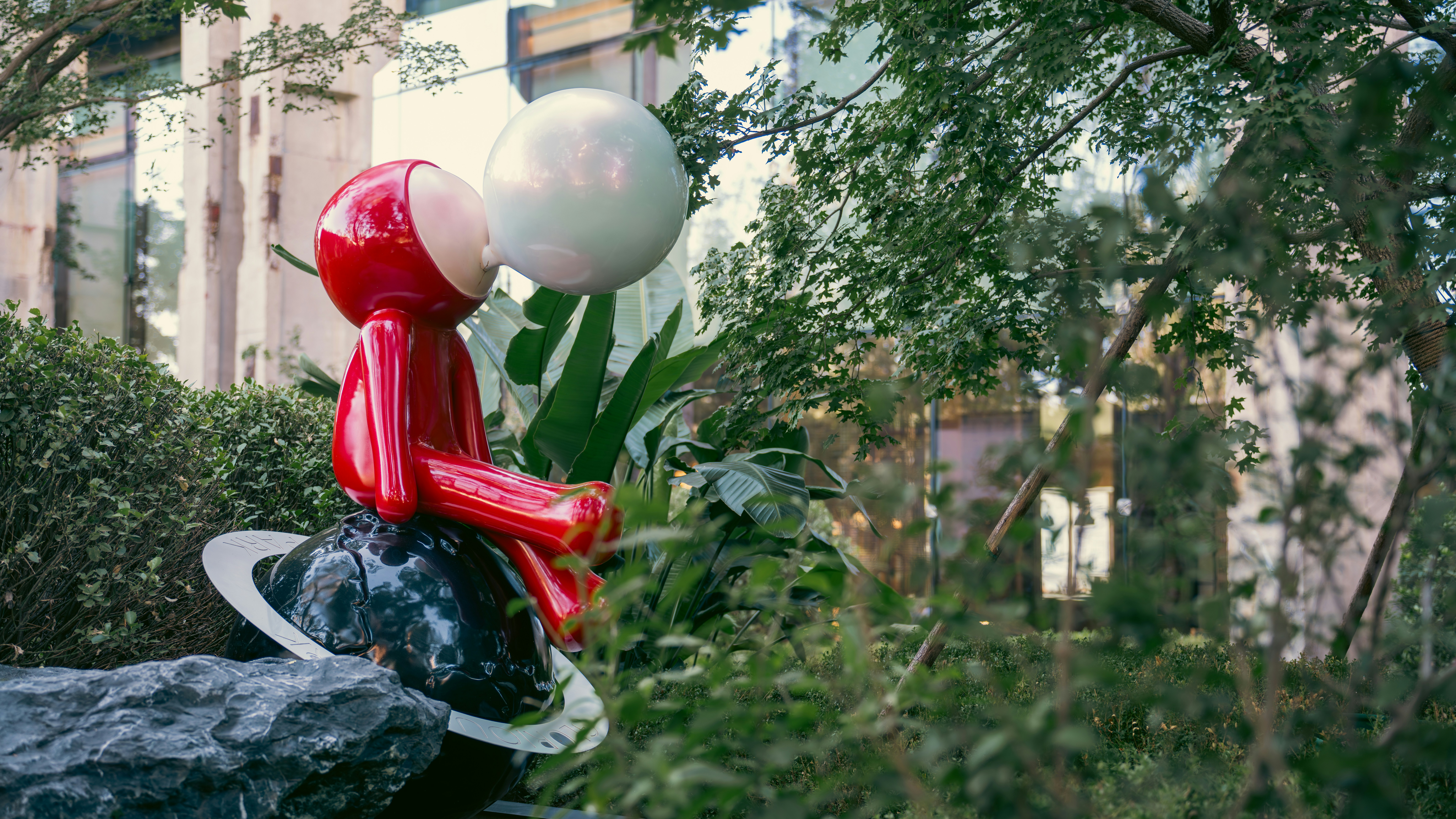 Red statue blowing a bubble.