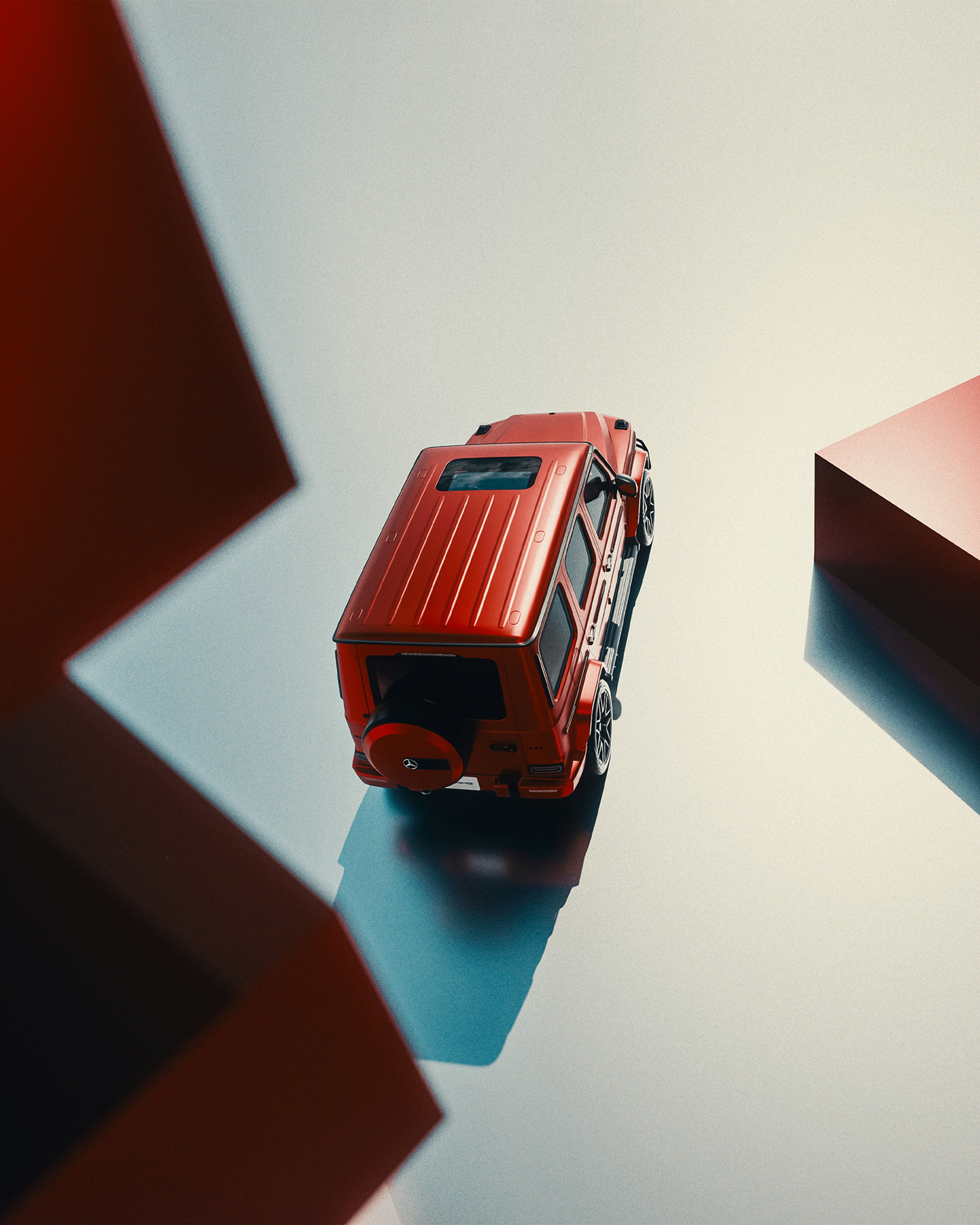 A red toy car sits on a reflective surface.