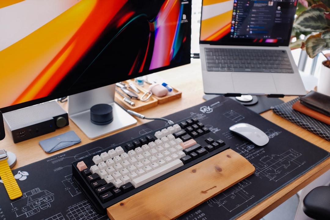 A modern desk setup with a keyboard and monitor.,