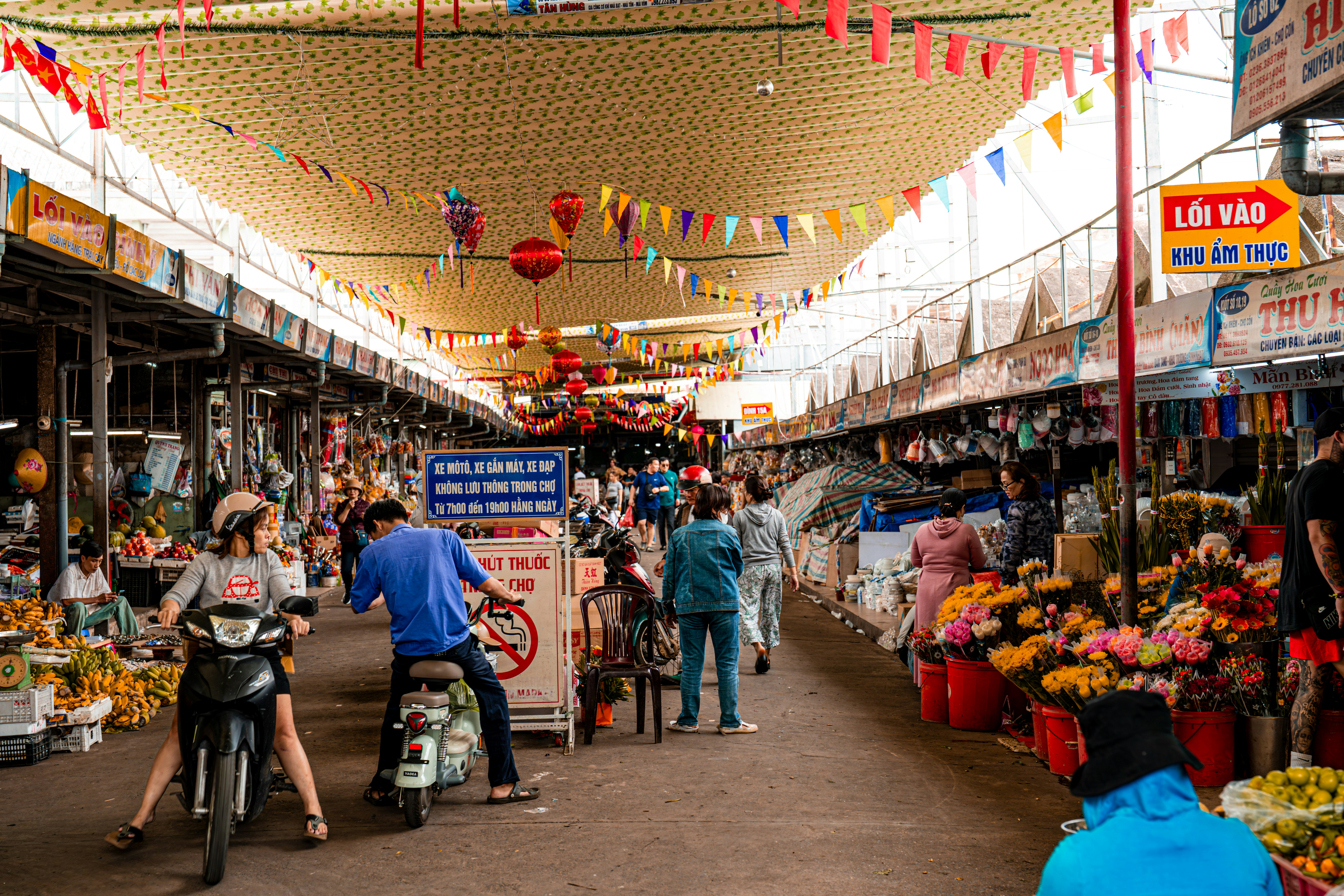 A busy rural market scene, filled with people, vibrant stalls, and a diverse array of goods, reflecting economic activity and community interaction - rural infrastructure development