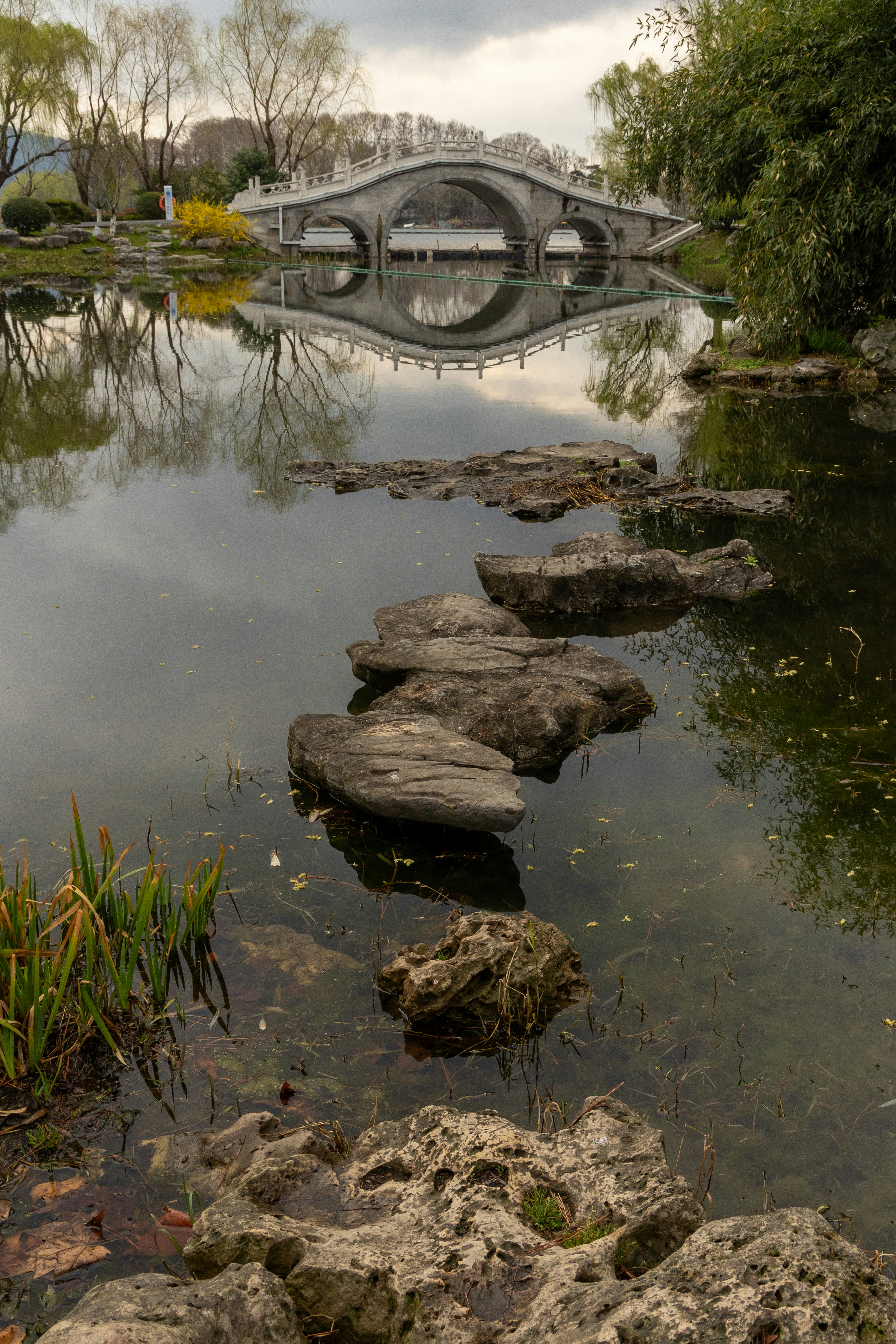 Un chemin de pierre mène à un beau pont en arc.
