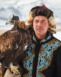 A man poses with his trained eagle.