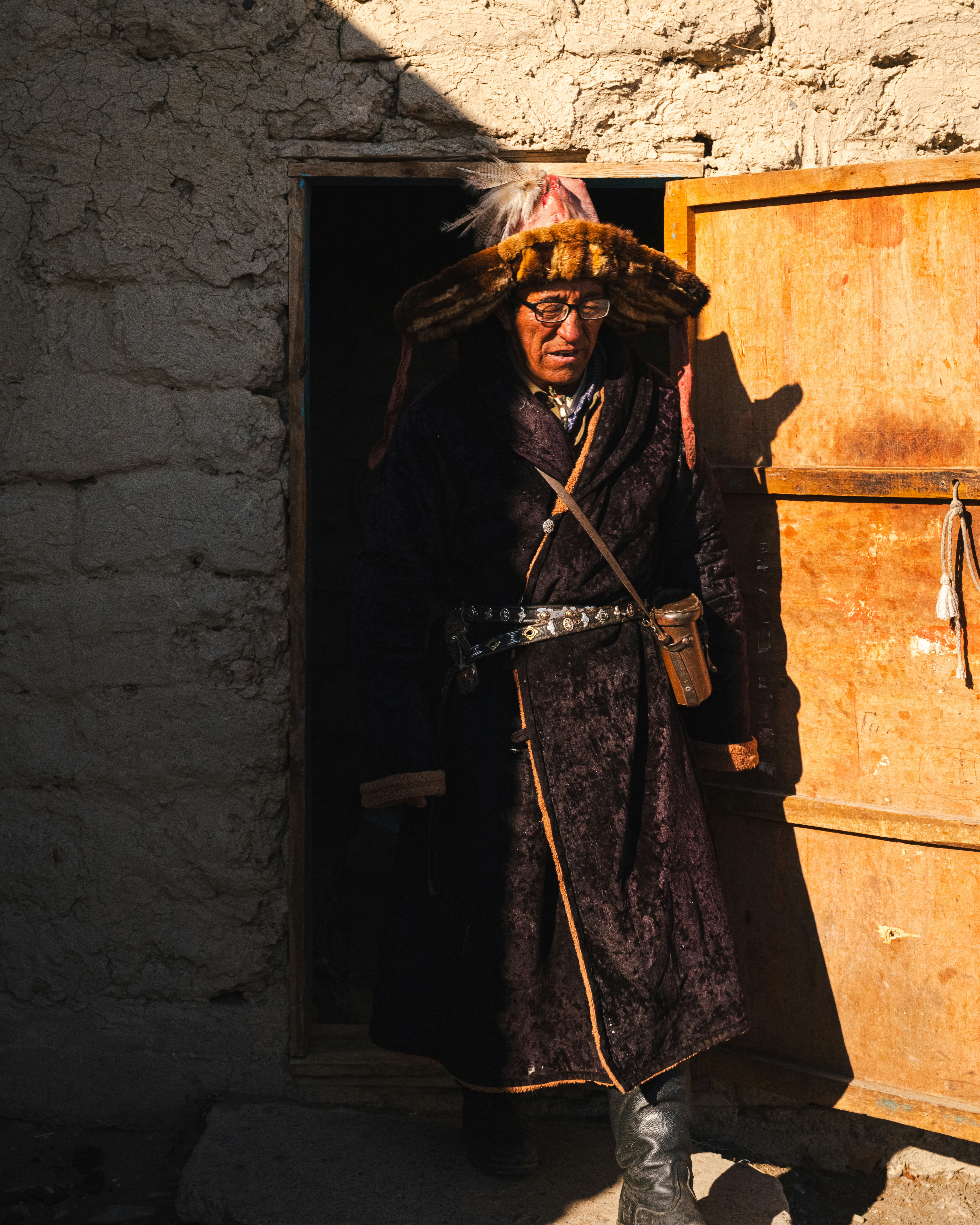 A person dressed traditionally exits a building.