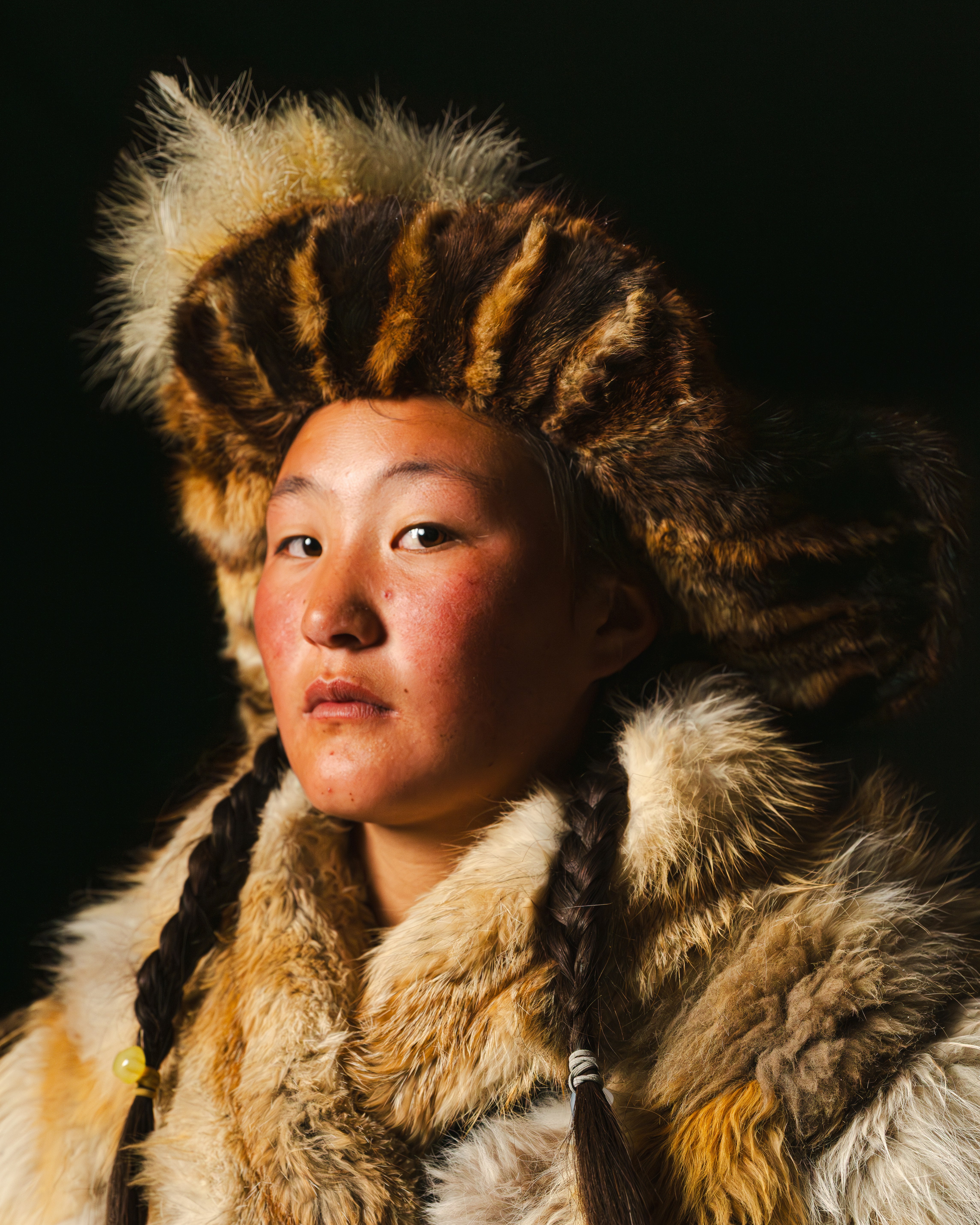 A woman wears traditional fur clothing.