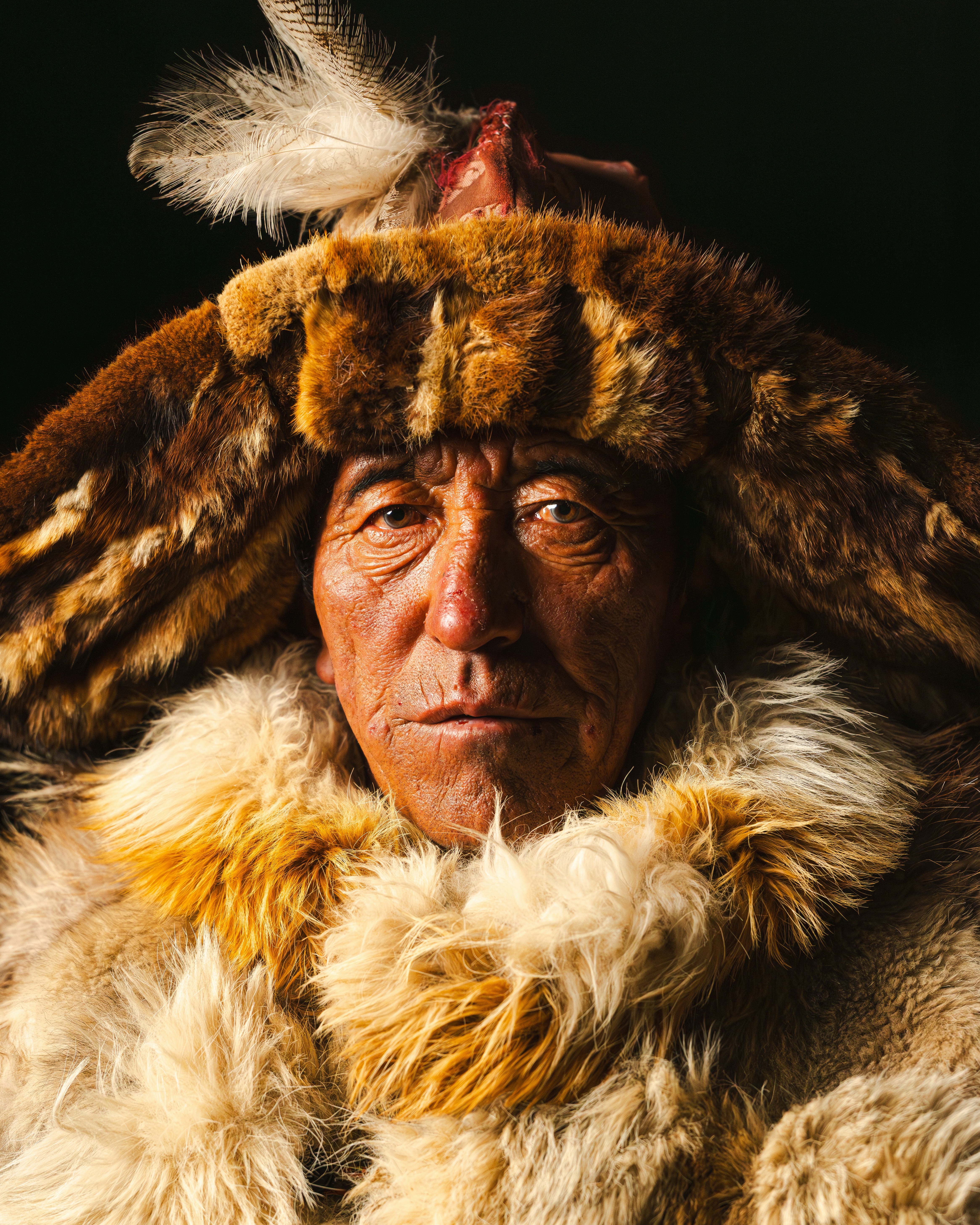 A man wears fur clothing and a hat.