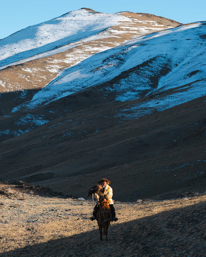 Chasseur à l'aigle à cheval dans les montagnes mongoles