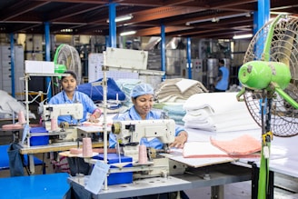 Workers operate sewing machines in a factory.