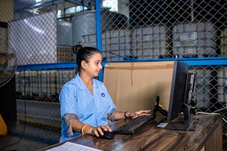 Woman working on computer in a warehouse.