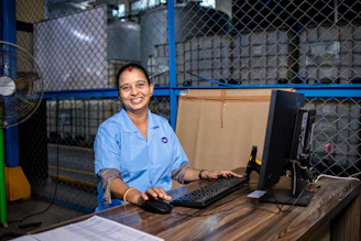 Woman working at a desk in a factory.